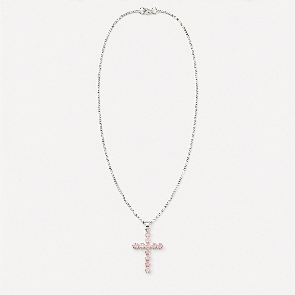 Pendentif croix en métal argenté serti de petits quartz roses, sur chaîne fine
