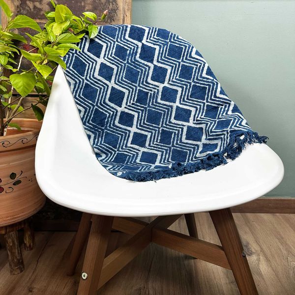 Petit jeté indigo 170 x 60 cm à motif de losanges blancs, posé sur le dossier d'une chaise blanche