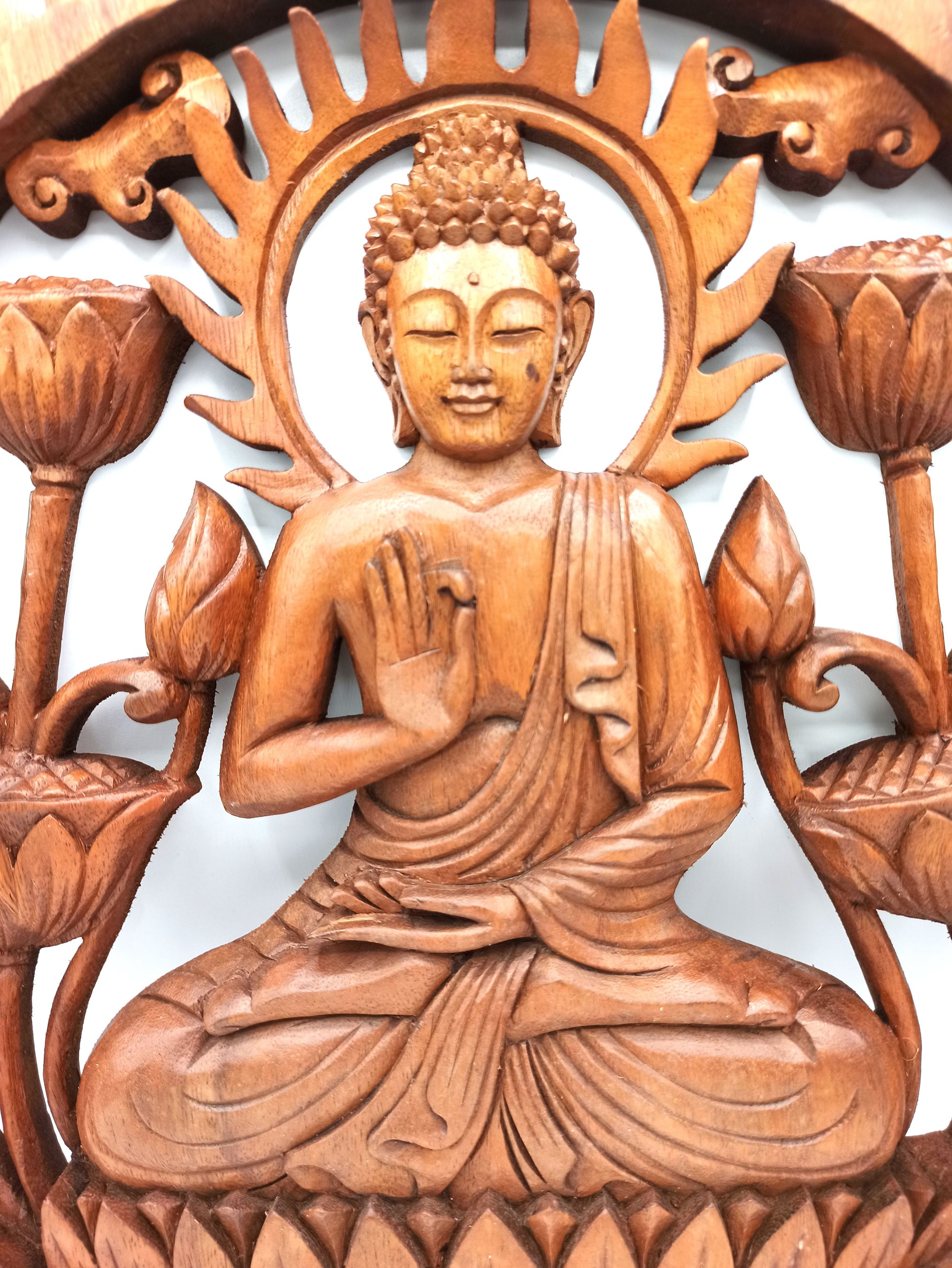 Détail du visage et de la main en geste d'enseignement du Bouddha sculpté en haut relief