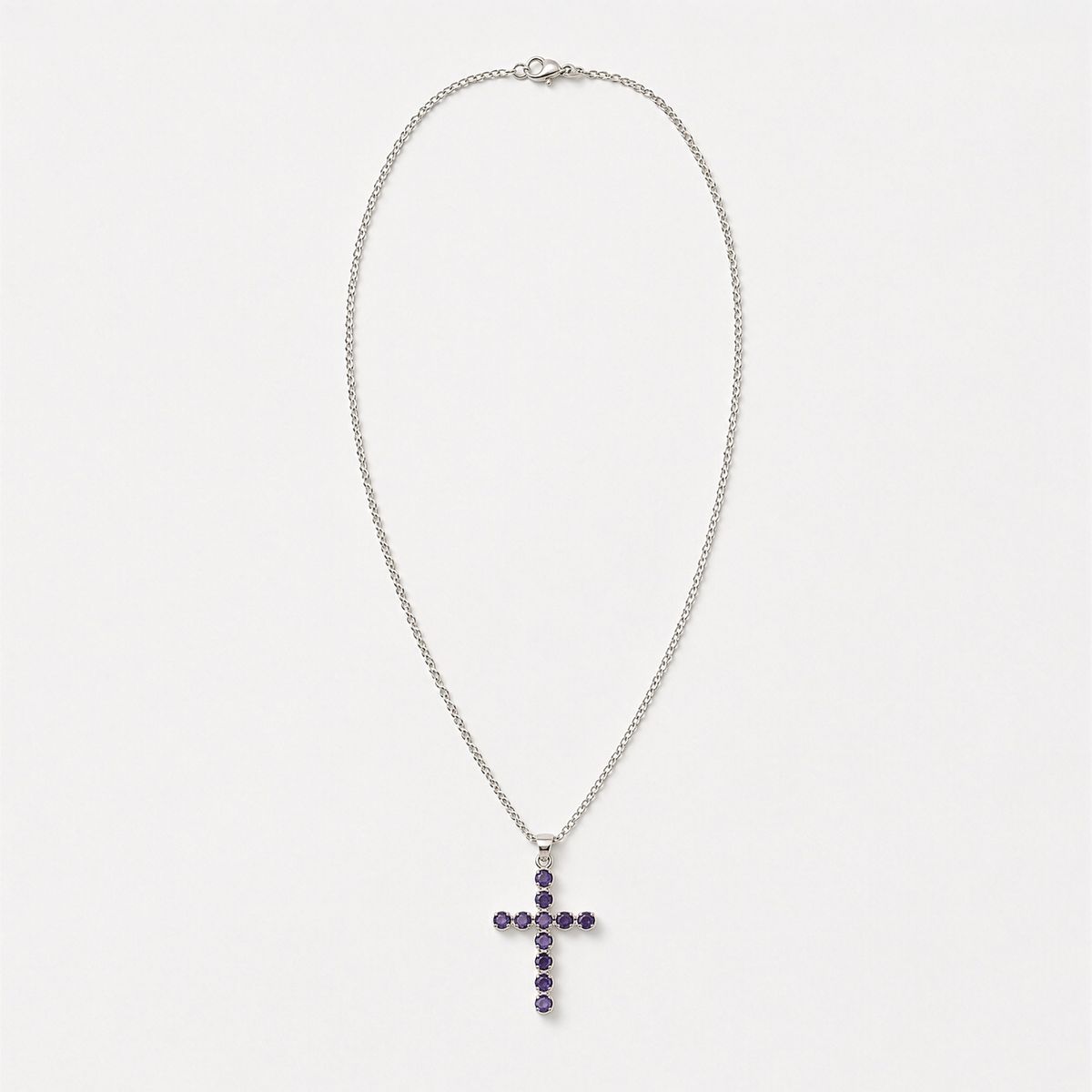 Pendentif croix en métal argenté serti de petites iolites bleu-violet, sur chaîne fine