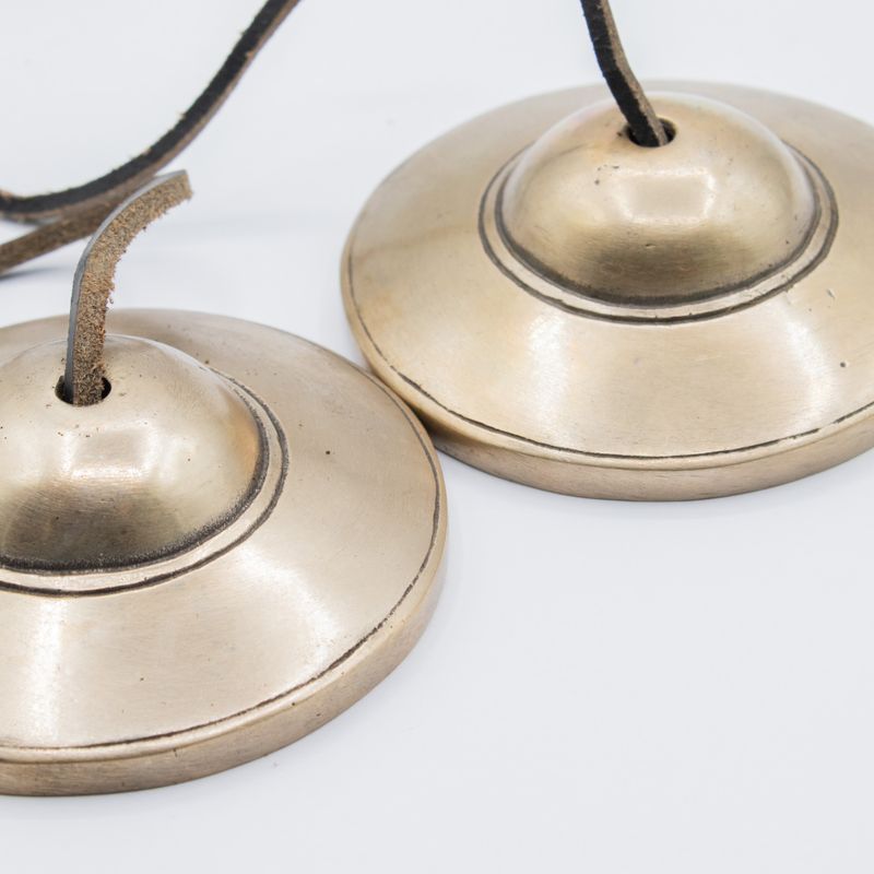 Cymbales tingsha lisses reliées par leur cordon