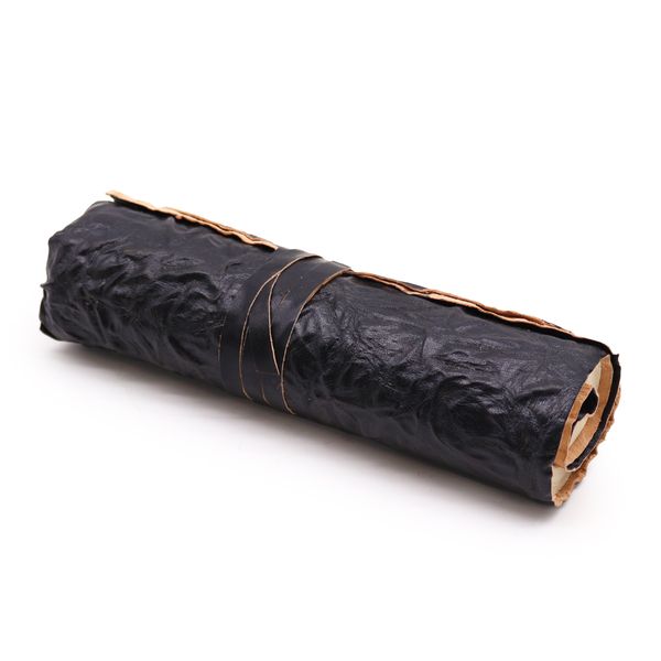 Carnet de voyage en cuir noir estampé, roulé sur lui-même, coins métalliques