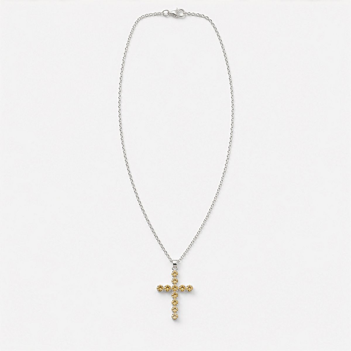 Pendentif croix en métal argenté serti de petites citrines dorées, sur chaîne fine