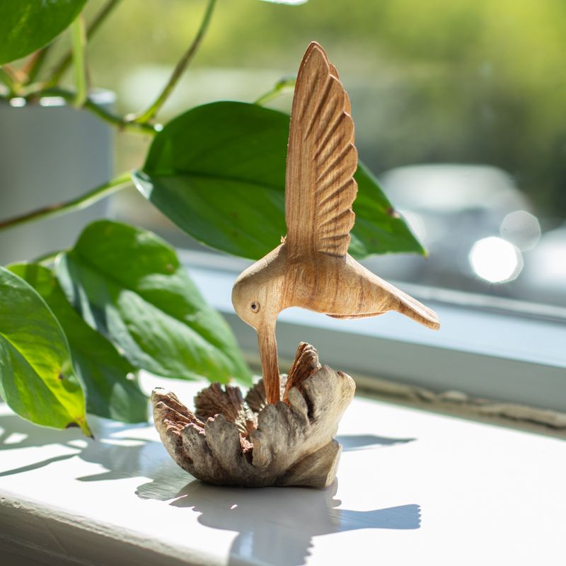 Détail du bec du colibri plongé dans la fleur sculptée