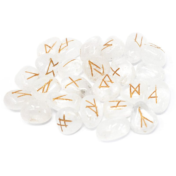 Jeu de 25 runes gravées en cristal de roche transparent, posées à côté de leur pochette