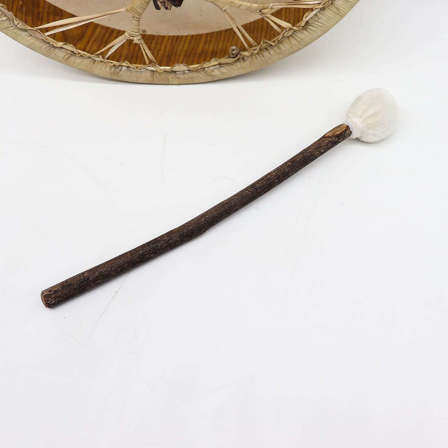 La mailloche fournie, manche en bois brut et tête ronde souple