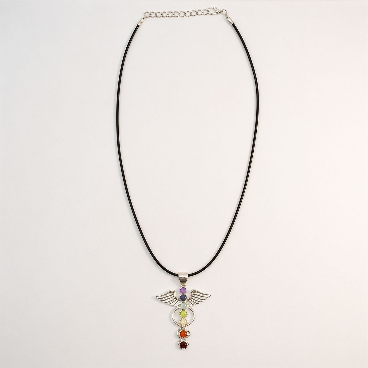 Pendentif à ailes déployées en métal argenté avec sept pierres de couleur alignées, sur cordon noir