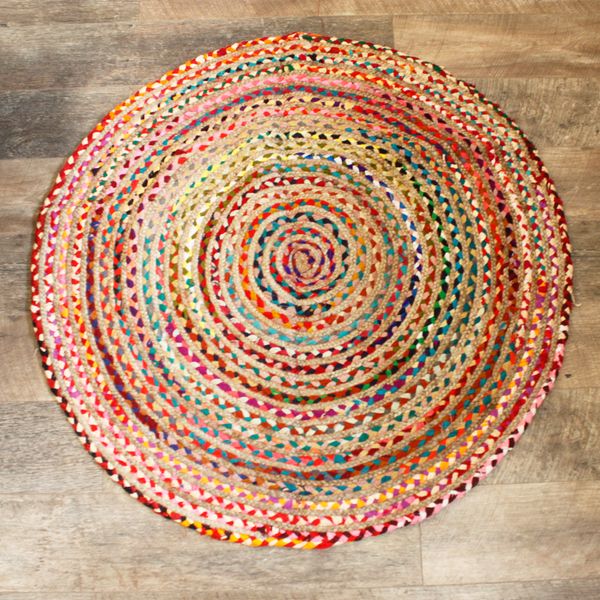 Tapis rond de 120 cm en jute et coton recyclé, tressé en spirale du centre vers le bord, posé sur un parquet