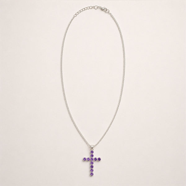 Pendentif croix en métal argenté serti de petites améthystes violettes, sur chaîne fine