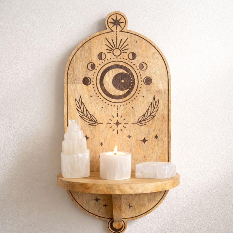 L'arche accrochée à un mur blanc, sa tablette demi-ronde portant une tour de sélénite, une bougie allumée et un photophore