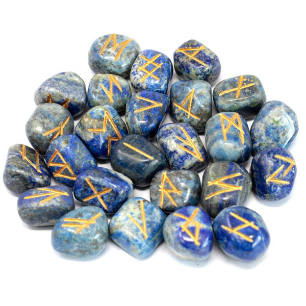 Jeu de 25 runes gravées en lapis-lazuli bleu nuit avec inclusions dorées, posées à côté de leur pochette