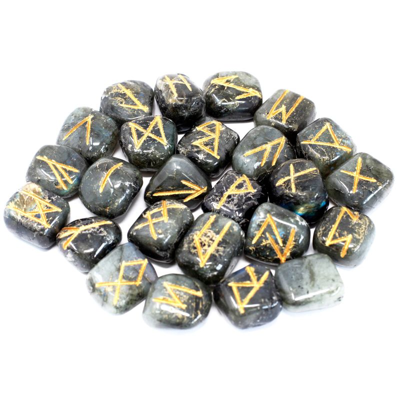 Jeu de 25 runes gravées en labradorite grise aux reflets bleus, posées à côté de leur pochette