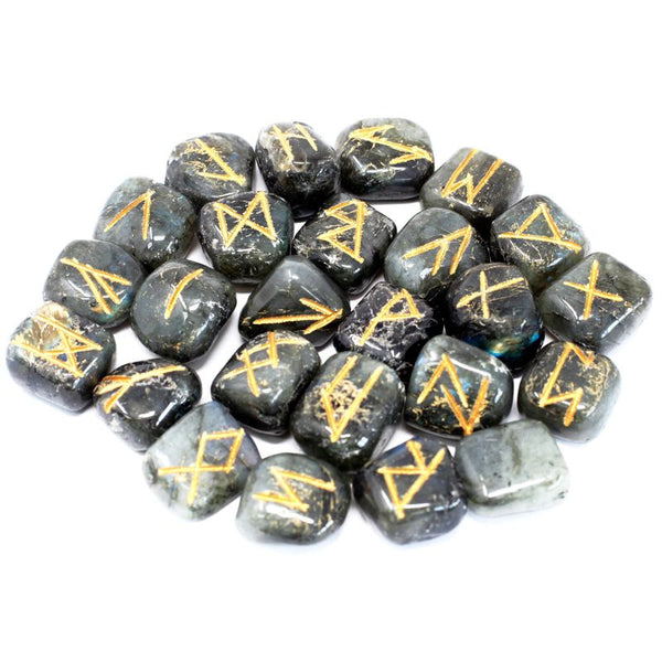 Jeu de 25 runes gravées en labradorite grise aux reflets bleus, posées à côté de leur pochette